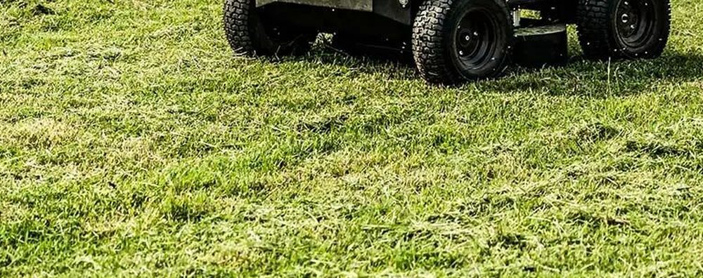Close view of the WANJI R1 cutting deck and drive wheels on grass