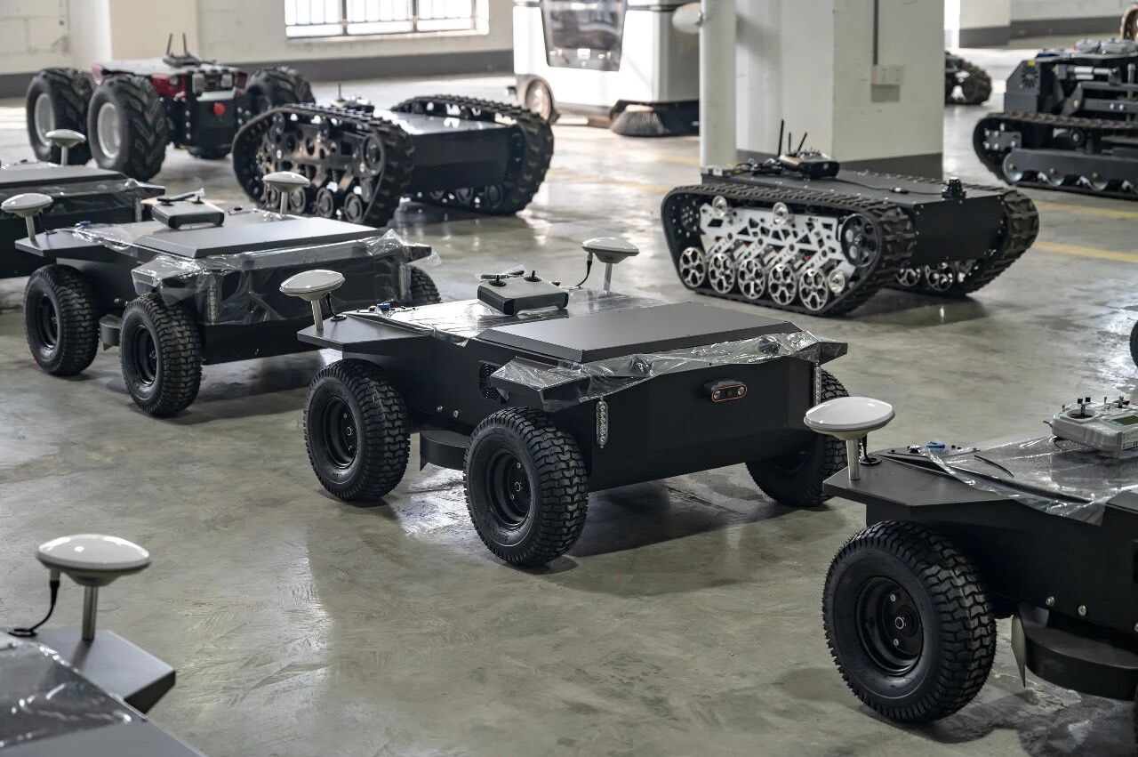 Close view of wheeled R1 and tracked T-900A autonomous mowers in the factory lineup