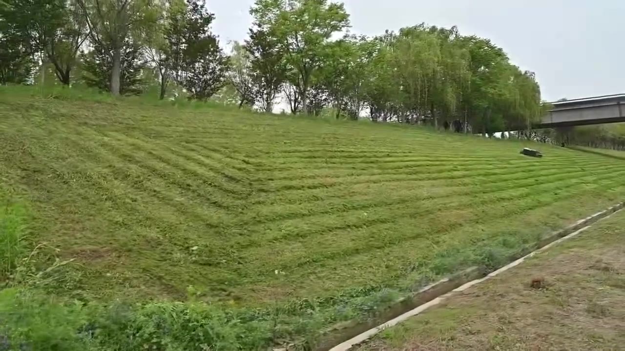 Tracked hybrid mower finishing a steep embankment