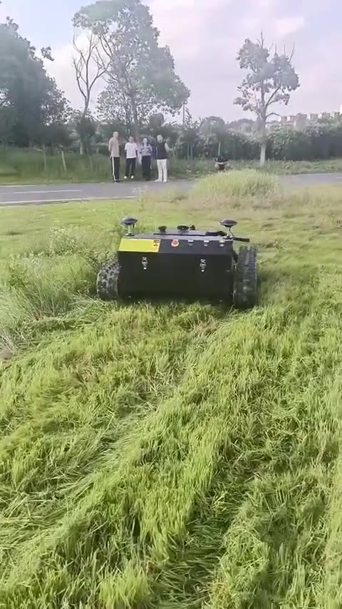 Tracked autonomous mower cutting tall rough grass on an energy site